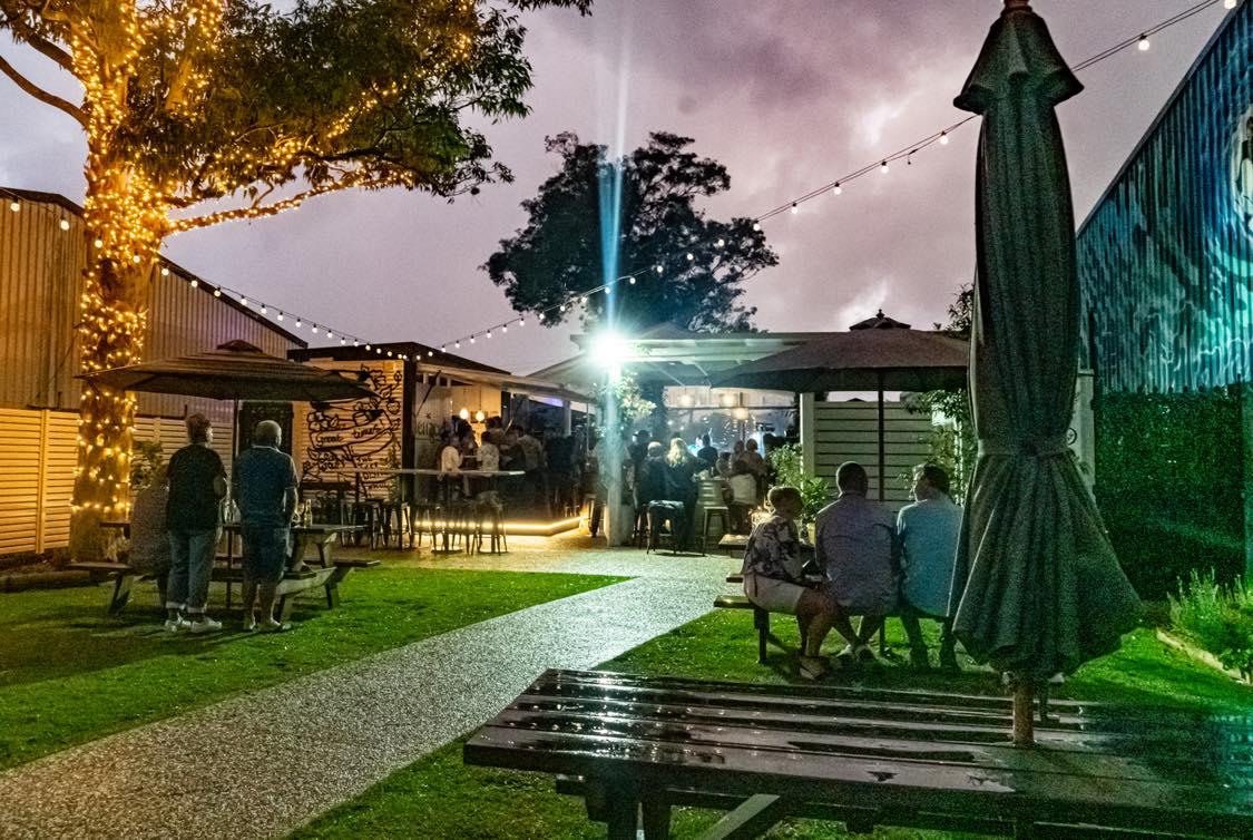 The Terrace at The Bowl Port Macquarie at night, with fairy-lit trees and guests on the lawn